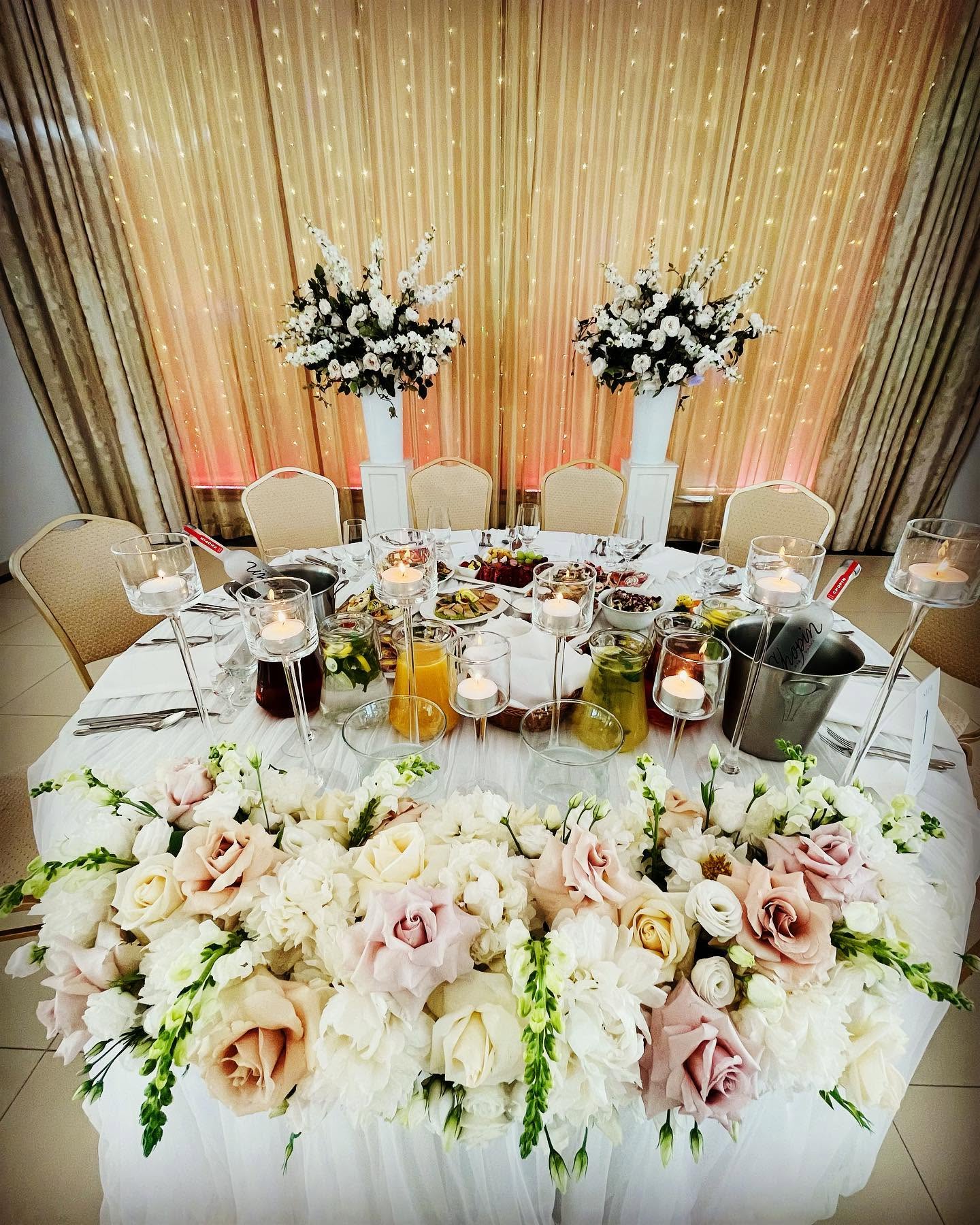 Elegancko nakryty stół Pary Młodej z dekoracjami kwiatowymi