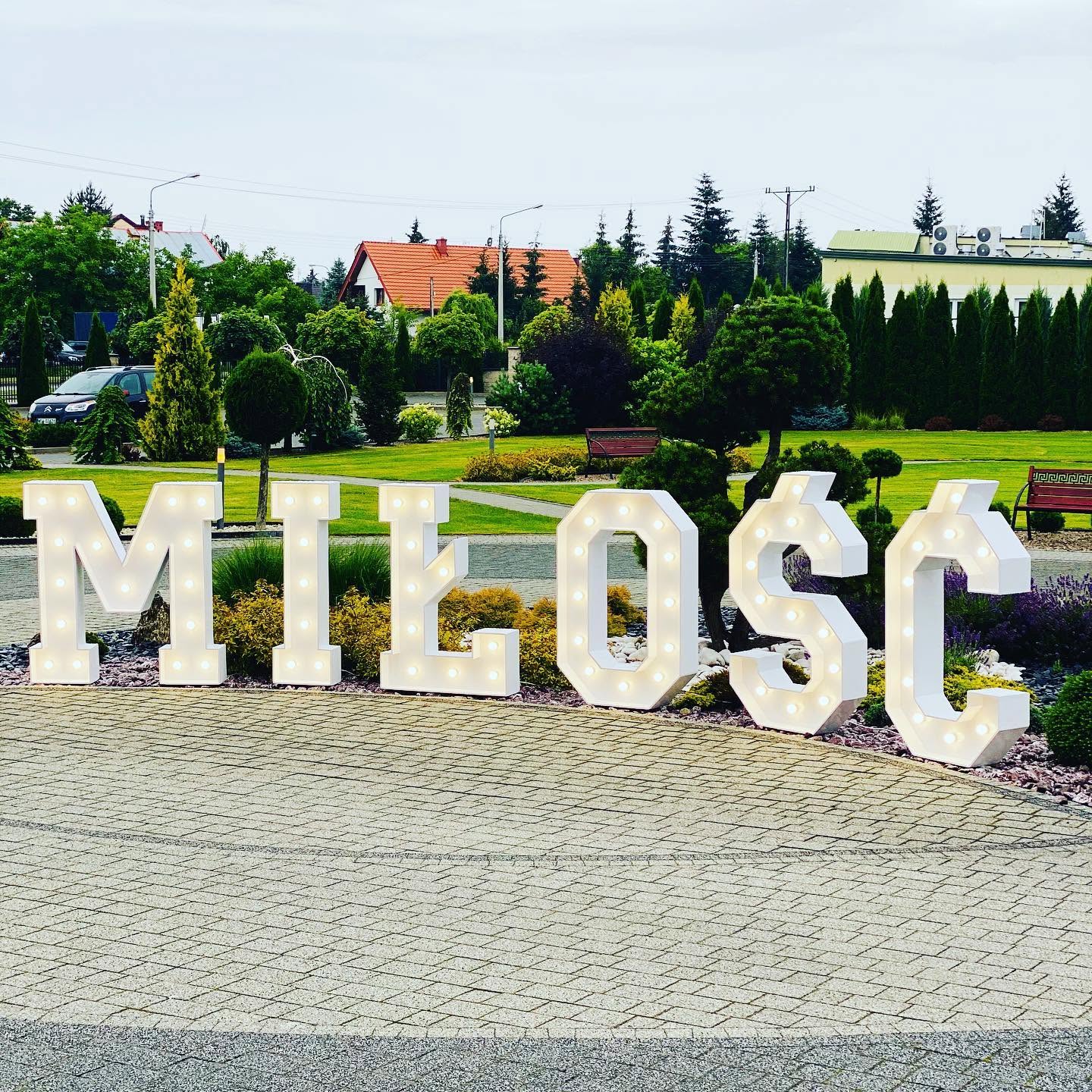 Świetlny napis MIŁOŚĆ przed Hotelem Aleksandria — dekoracja weselna